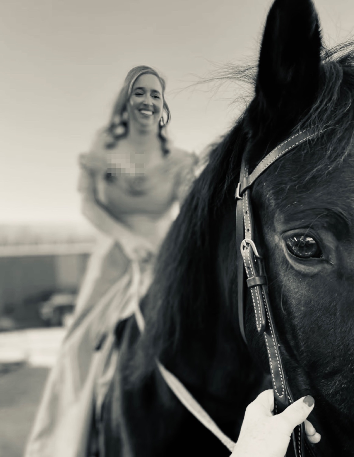 A bride arriving on horseback in a black and white photograph