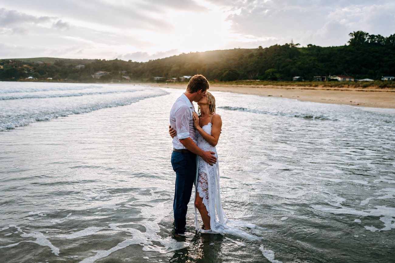 A couple holding each other in the shallows at sunset